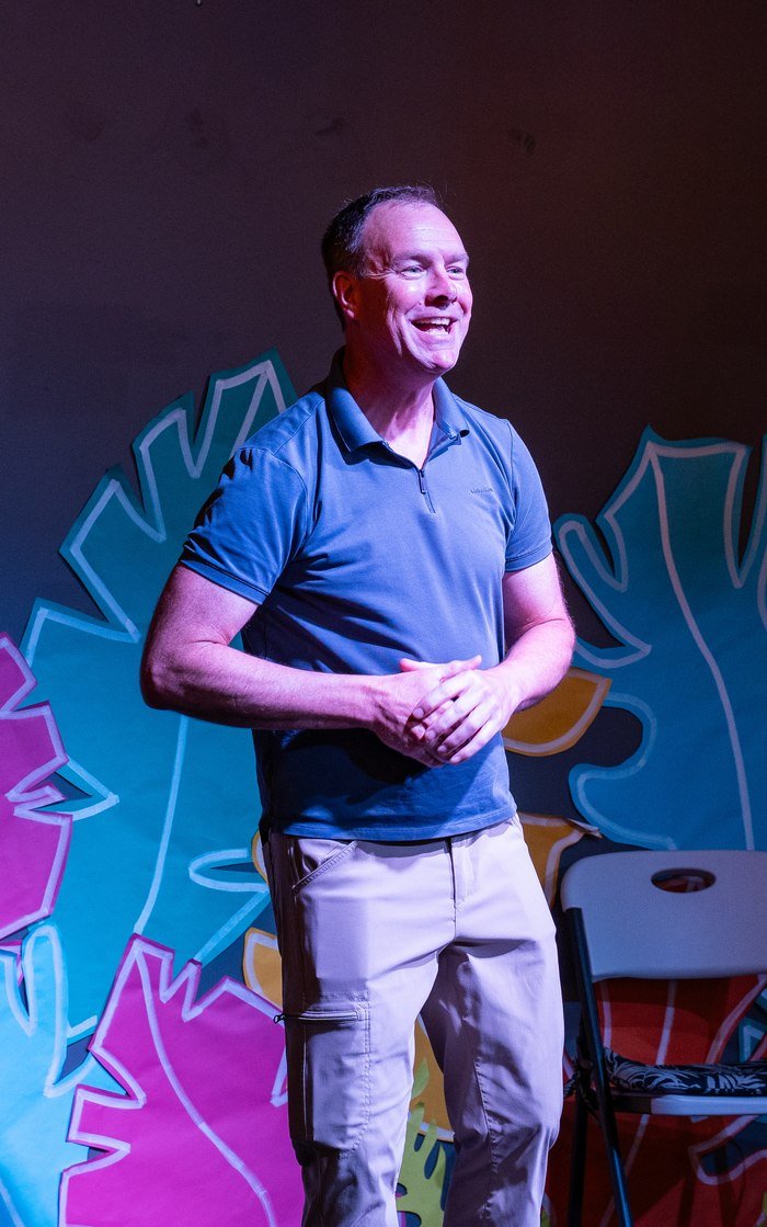 Patrick McInnis leading an improv scene on stage